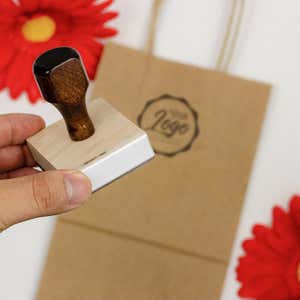 An example of a hand holding a custom logo stamp